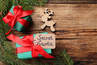 Photo of Flat lay composition with presents from secret Santa on wooden table, space for text