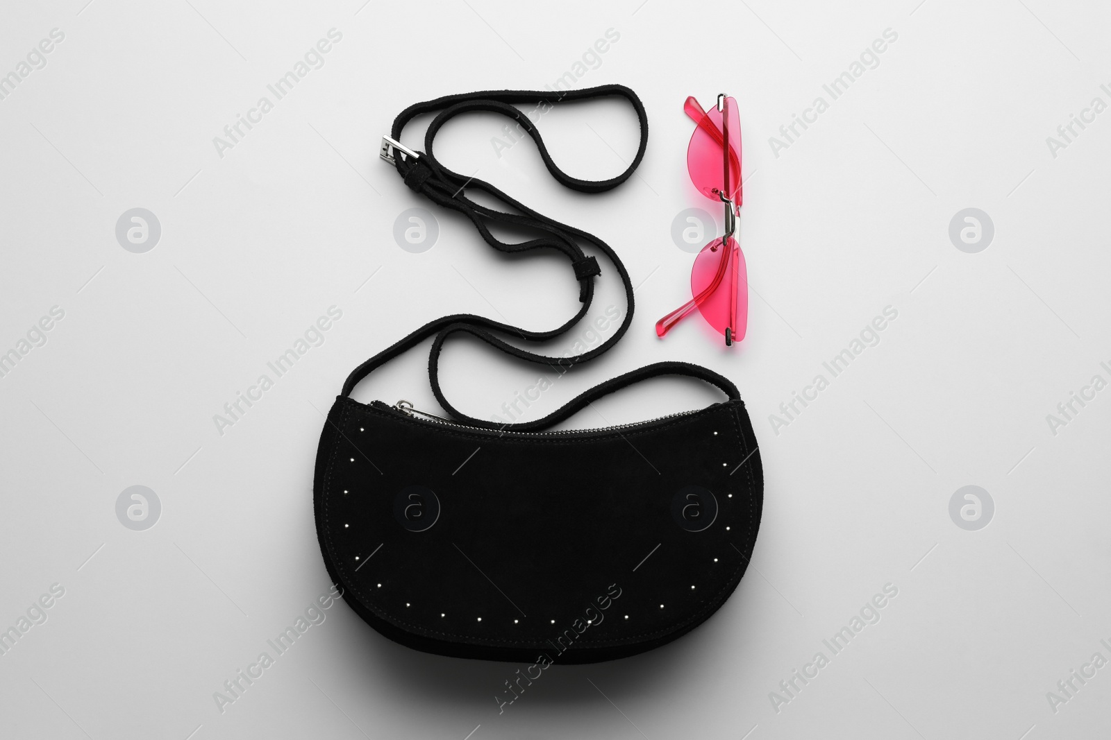 Stylish woman's bag and sunglasses on light background, flat lay Photo of Stylish woman's bag and sunglasses on light background, flat lay