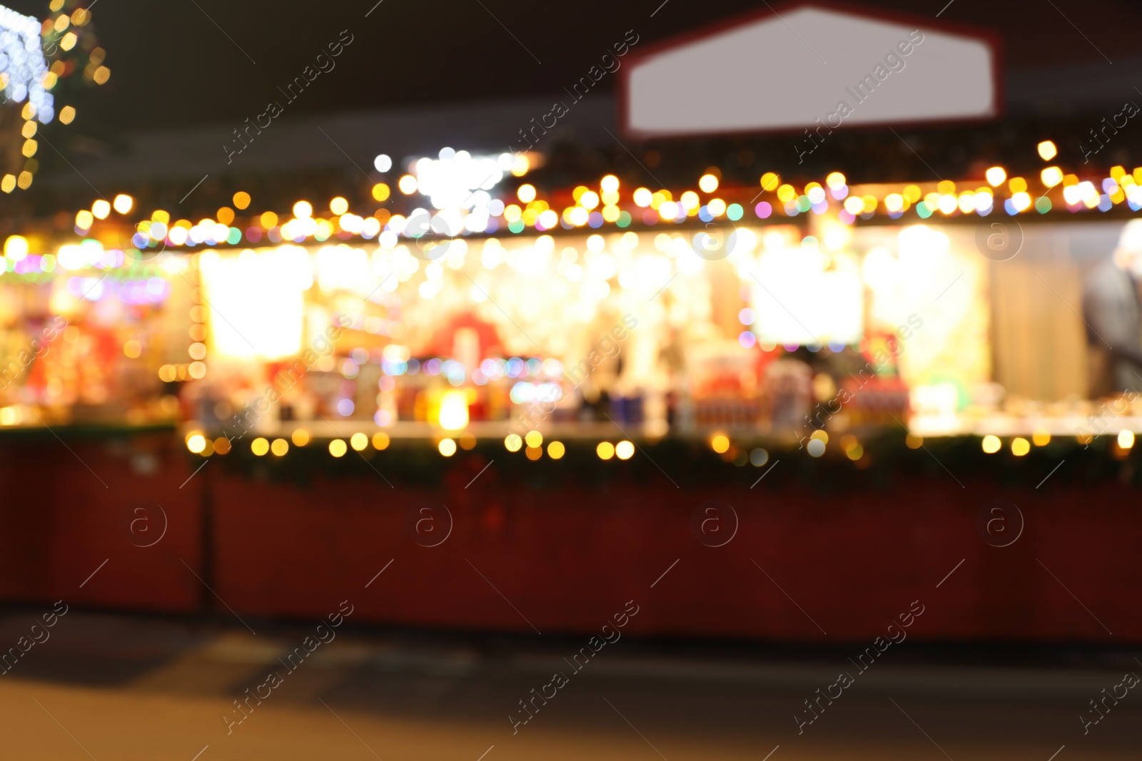 Blurred view of Christmas fair stalls outdoors at night Photo of Blurred view of Christmas fair stalls outdoors at night