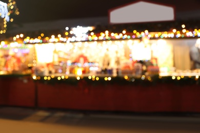 Blurred view of Christmas fair stalls outdoors at night Photo of Blurred view of Christmas fair stalls outdoors at night