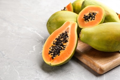 Fresh ripe papaya fruits on light grey table. Space for text Photo of Fresh ripe papaya fruits on light grey table. Space for text