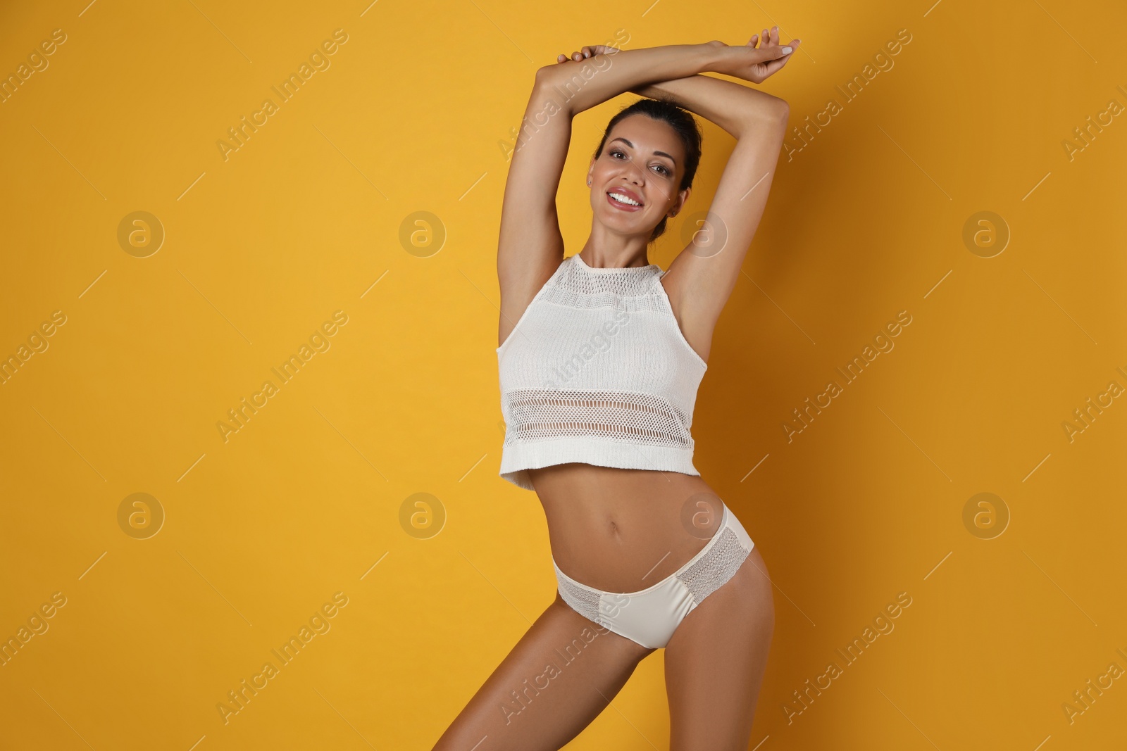 Beautiful woman in white sexy panties on yellow background, space for text Photo of Beautiful woman in white sexy panties on yellow background, space for text
