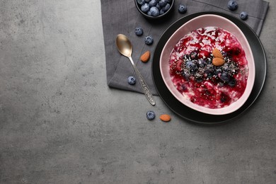 Tasty oatmeal porridge with toppings on grey table, flat lay. Space for text Photo of Tasty oatmeal porridge with toppings on grey table, flat lay. Space for text