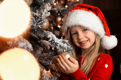 Cute little child near Christmas tree at home Photo of Cute little child near Christmas tree at home