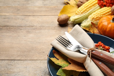 Seasonal table setting with autumn leaves and vegetables on wooden background, space for text. Thanksgiving Day Photo of Seasonal table setting with autumn leaves and vegetables on wooden background, space for text. Thanksgiving Day