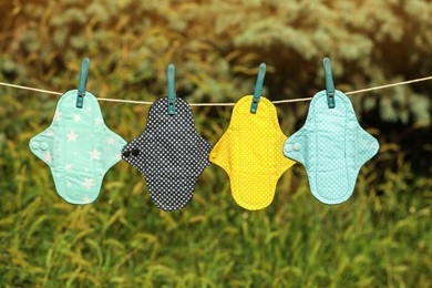 Many different menstrual cloth pads hanging on rope outdoors Photo of Many different menstrual cloth pads hanging on rope outdoors