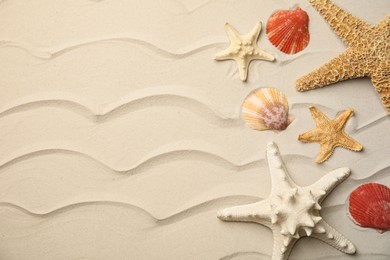 Beautiful sea stars and shells on sand, flat lay. Space for text Photo of Beautiful sea stars and shells on sand, flat lay. Space for text