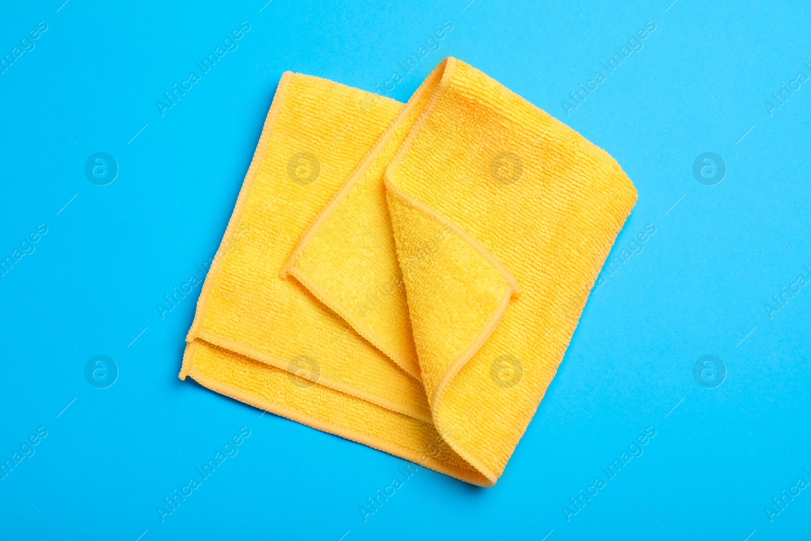 Orange microfiber cloth on light blue background, top view Photo of Orange microfiber cloth on light blue background, top view