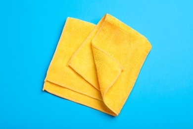 Orange microfiber cloth on light blue background, top view Photo of Orange microfiber cloth on light blue background, top view