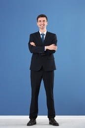 Business trainer standing on color wall background Photo of Business trainer standing on color wall background