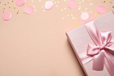 Pink gift box and confetti on color background, top view. Space for text Photo of Pink gift box and confetti on color background, top view. Space for text