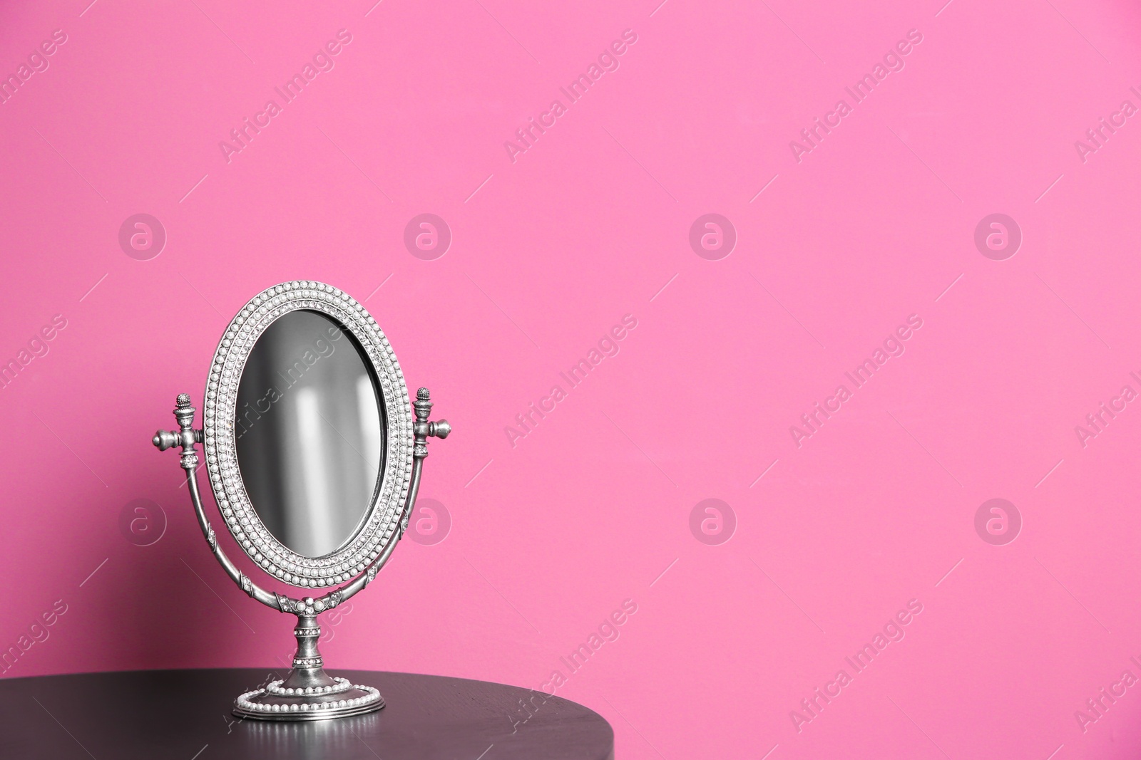 Stylish mirror on table near color wall Photo of Stylish mirror on table near color wall