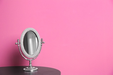 Stylish mirror on table near color wall Photo of Stylish mirror on table near color wall