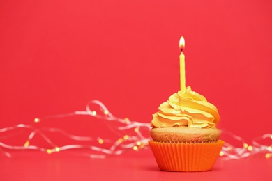 Birthday cupcake with candle on color background Photo of Birthday cupcake with candle on color background