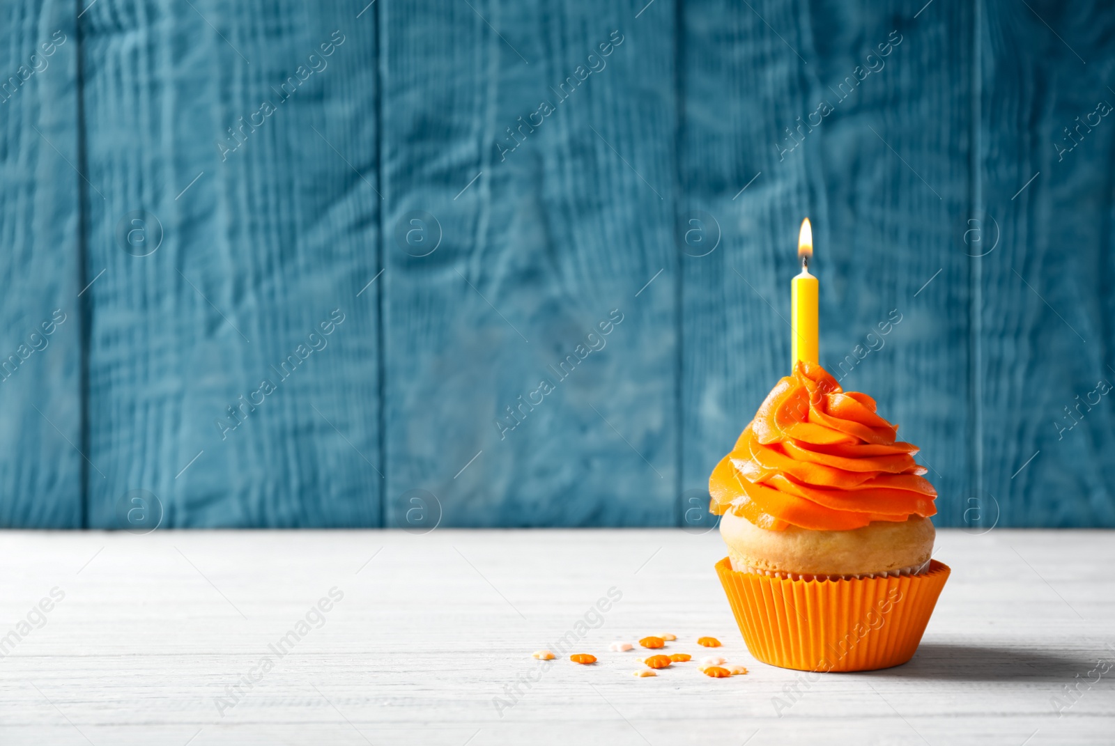 Delicious birthday cupcake with burning candle on table Photo of Delicious birthday cupcake with burning candle on table