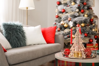 Image of Christmas decor with candles on table in living room. Festive interior