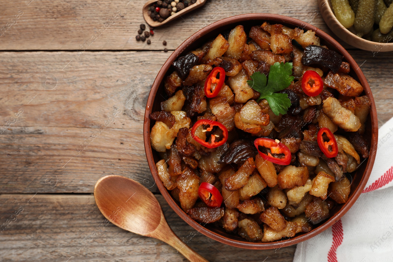 Tasty fried cracklings on wooden table, flat lay. Cooked pork lard Photo of Tasty fried cracklings on wooden table, flat lay. Cooked pork lard
