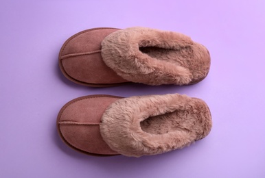 Pair of stylish soft slippers on violet background, flat lay Photo of Pair of stylish soft slippers on violet background, flat lay