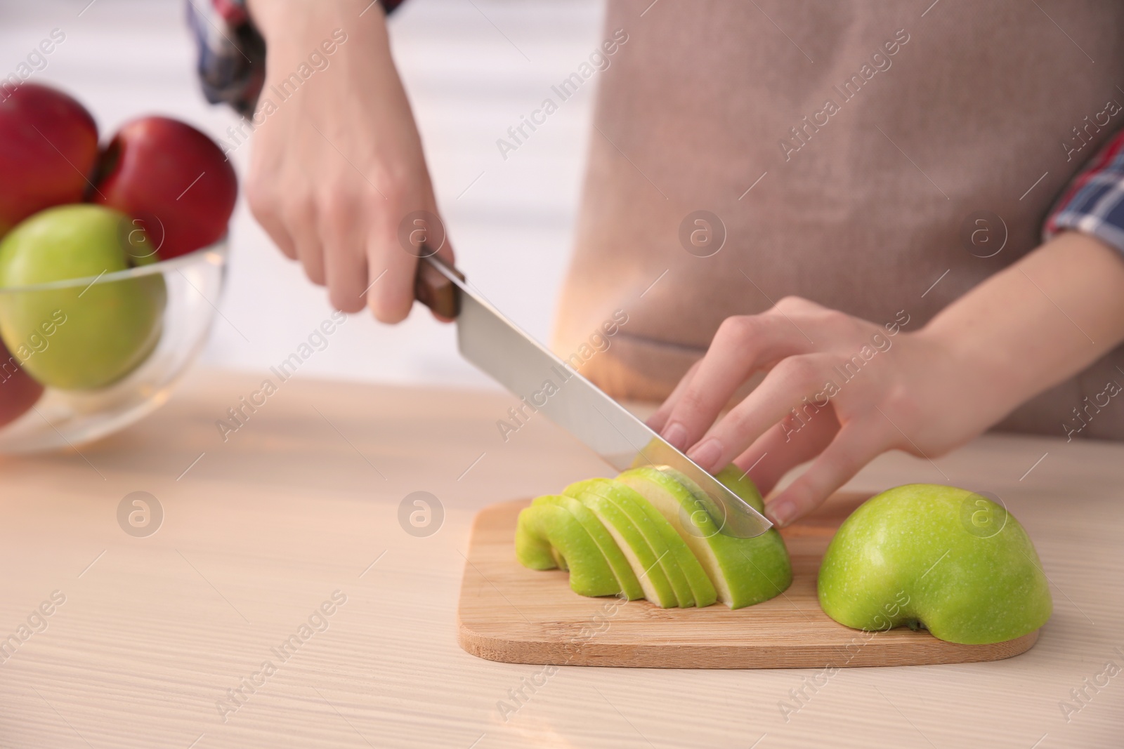 Woman cutting ripe apple at table Photo of Woman cutting ripe apple at table