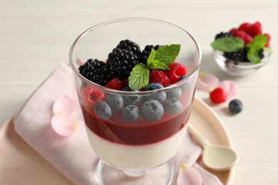 Delicious panna cotta with berries in glass dessert bowl, closeup Photo of Delicious panna cotta with berries in glass dessert bowl, closeup