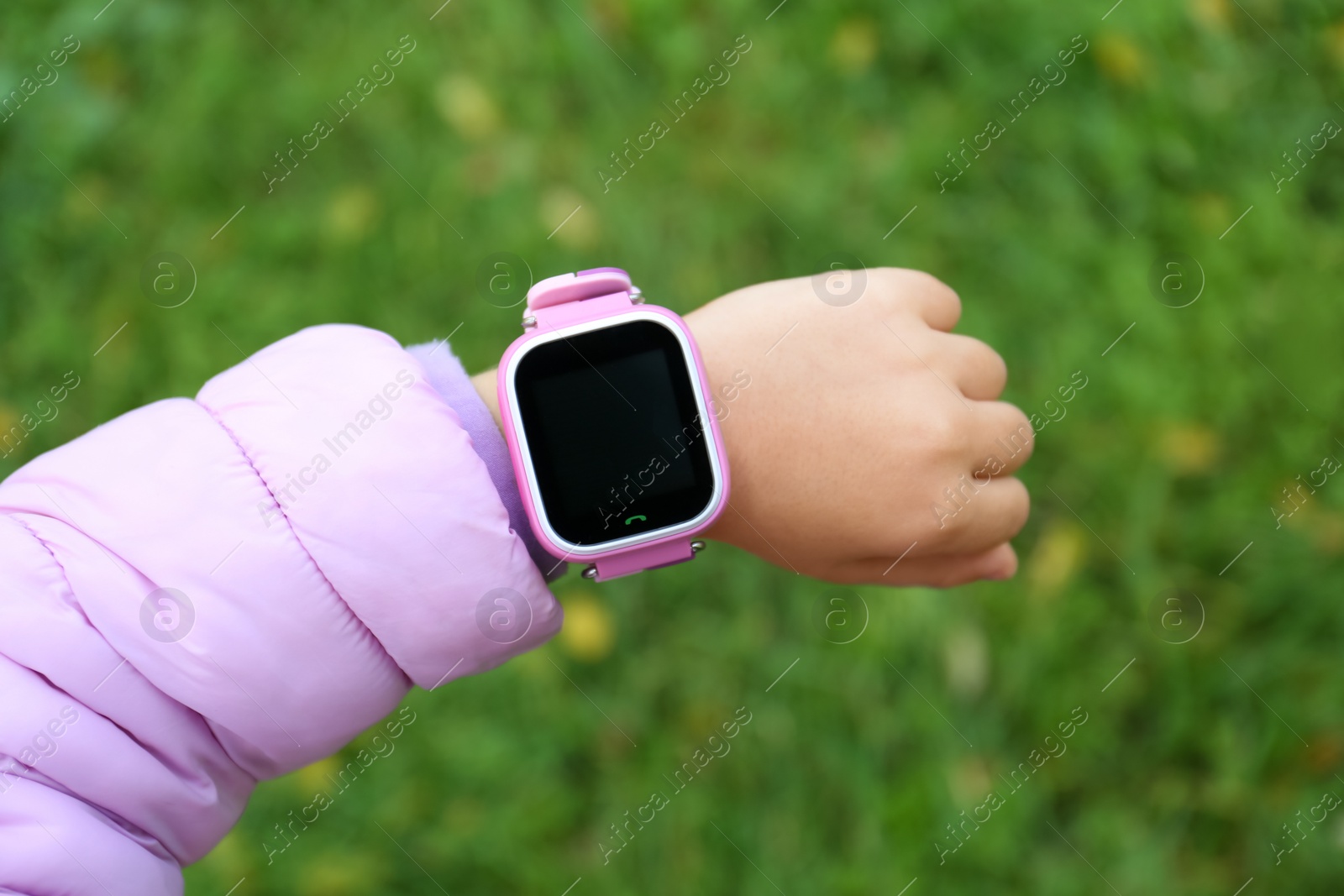 Little girl with stylish smart watch outdoors, closeup Photo of Little girl with stylish smart watch outdoors, closeup