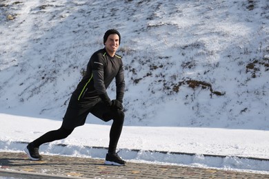 Man doing sports exercises outdoors on winter day. Space for text Photo of Man doing sports exercises outdoors on winter day. Space for text