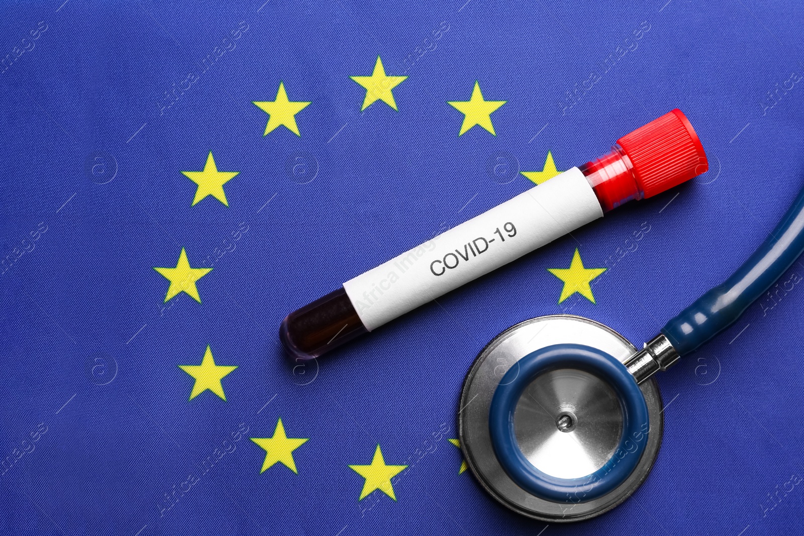 Stethoscope and test tube with blood sample on European Union flag background, flat lay. Coronavirus outbreak Photo of Stethoscope and test tube with blood sample on European Union flag background, flat lay. Coronavirus outbreak