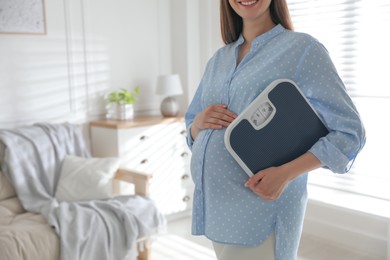 Young pregnant woman with scales at home, closeup Photo of Young pregnant woman with scales at home, closeup