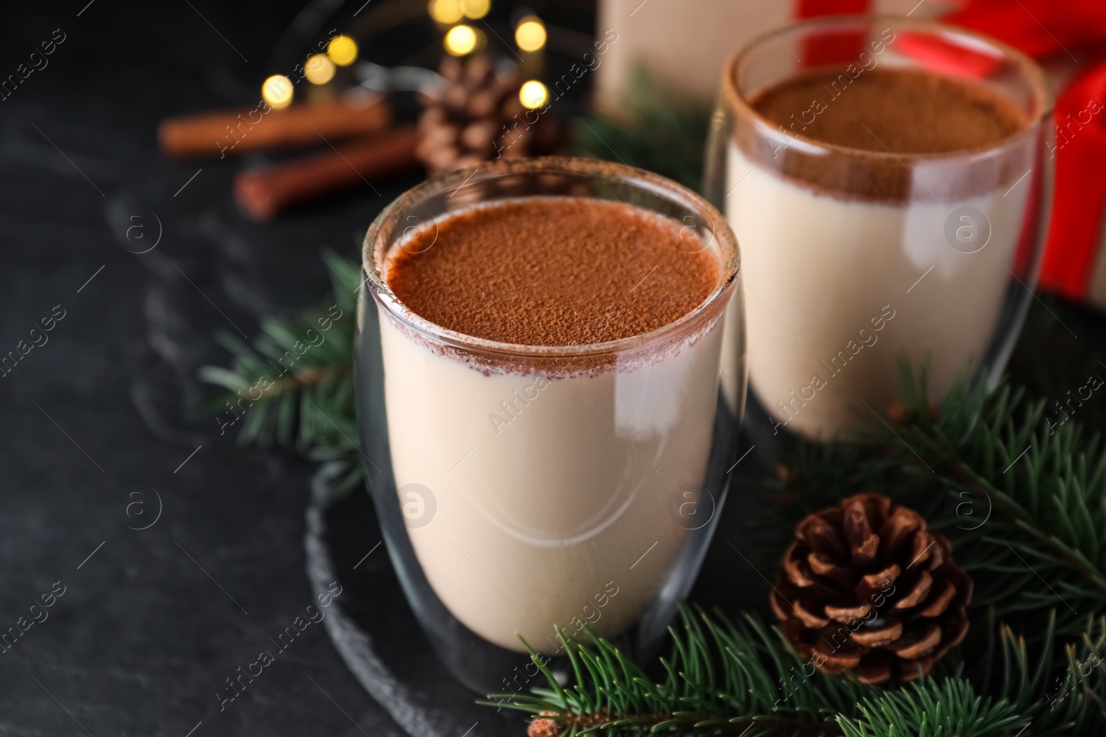 Delicious Christmas cocktail with liqueur on black table Photo of Delicious Christmas cocktail with liqueur on black table