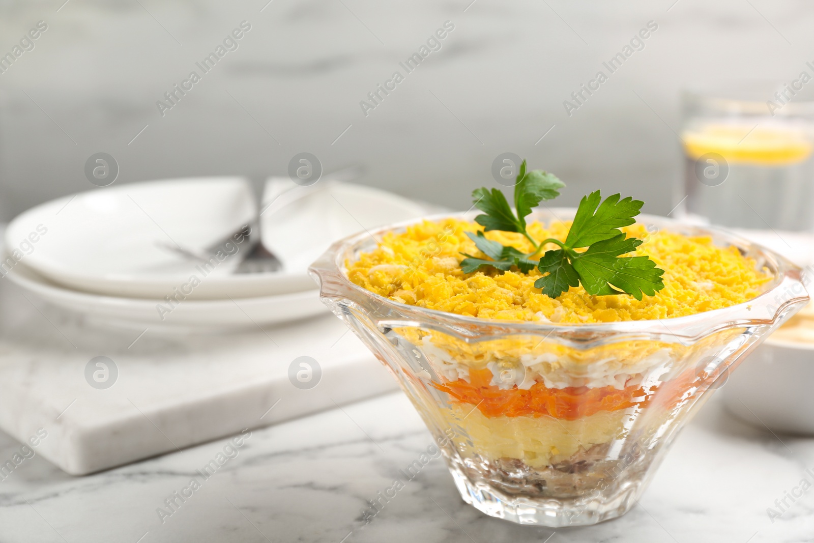 Traditional russian salad Mimosa served on white marble table. Space for text Photo of Traditional russian salad Mimosa served on white marble table. Space for text