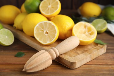 Squeezer with lemons on wooden table, closeup Photo of Squeezer with lemons on wooden table, closeup