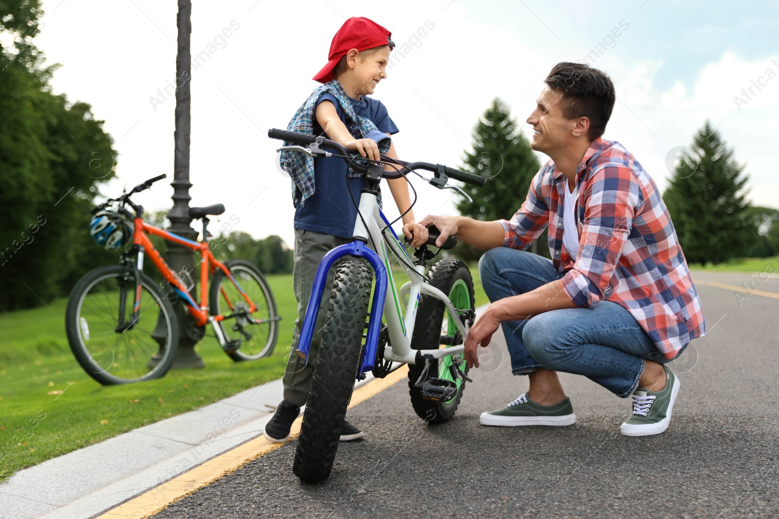 Dad teaching son to ride bicycle outdoors Image of Dad teaching son to ride bicycle outdoors