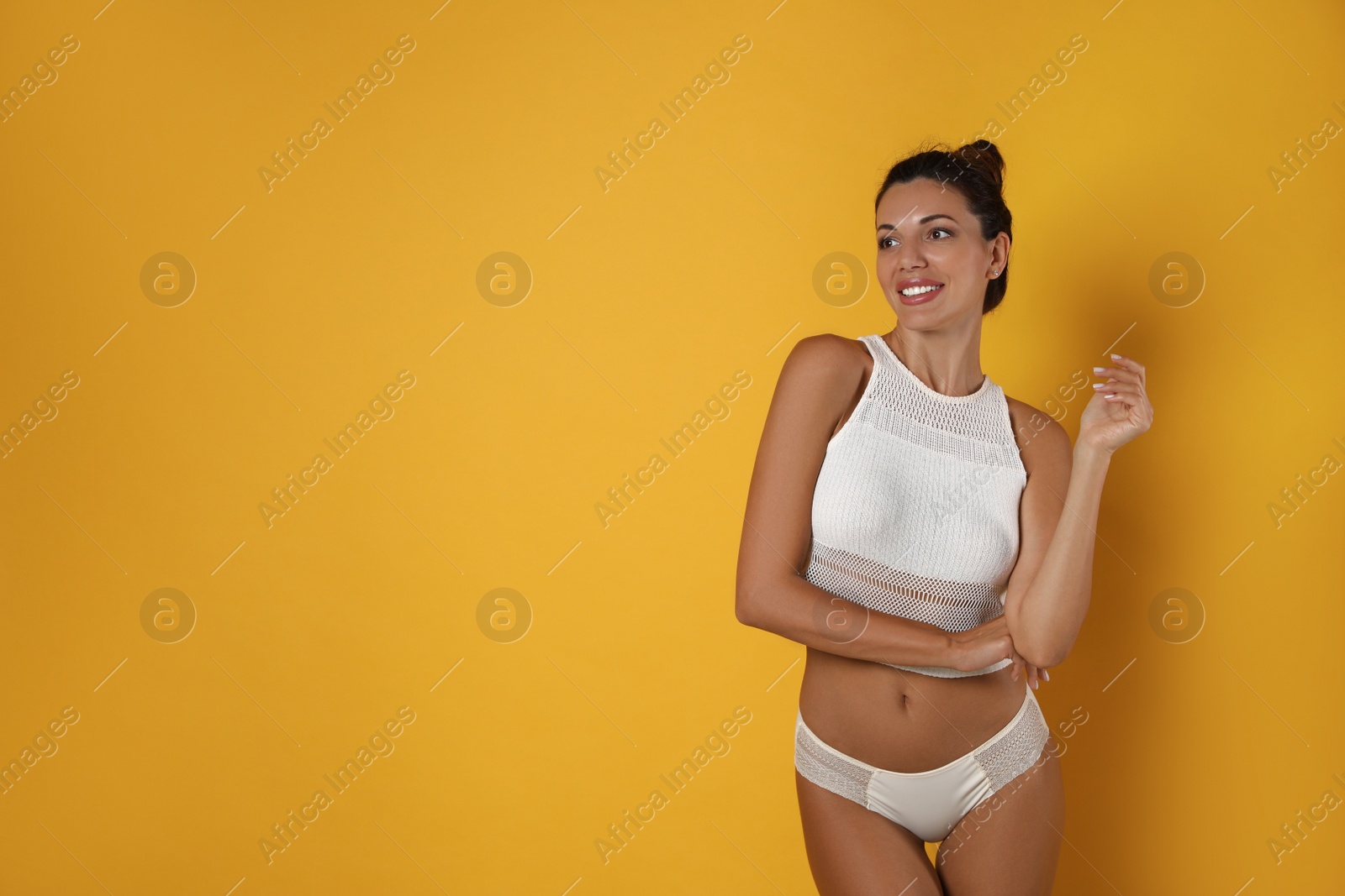 Beautiful woman in white sexy panties on yellow background, space for text Photo of Beautiful woman in white sexy panties on yellow background, space for text