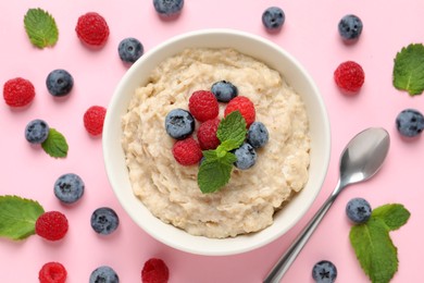 Tasty oatmeal porridge with raspberries and blueberries in bowl on pink background, flat lay Photo of Tasty oatmeal porridge with raspberries and blueberries in bowl on pink background, flat lay