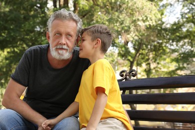Senior man with his little grandson resting together in park Photo of Senior man with his little grandson resting together in park