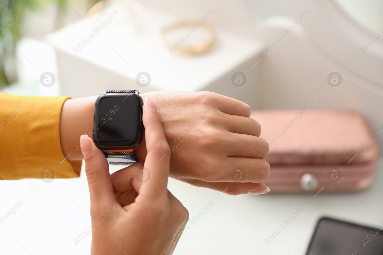 Woman checking stylish smart watch at home, closeup Image of Woman checking stylish smart watch at home, closeup