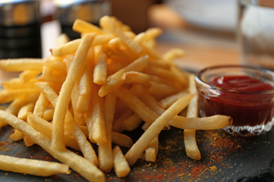 Tasty French fries with red sauce served on table in cafe, closeup Photo of Tasty French fries with red sauce served on table in cafe, closeup