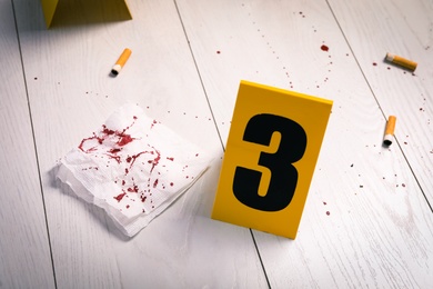 Bloody napkin, stubs and crime scene marker on white wooden table Photo of Bloody napkin, stubs and crime scene marker on white wooden table