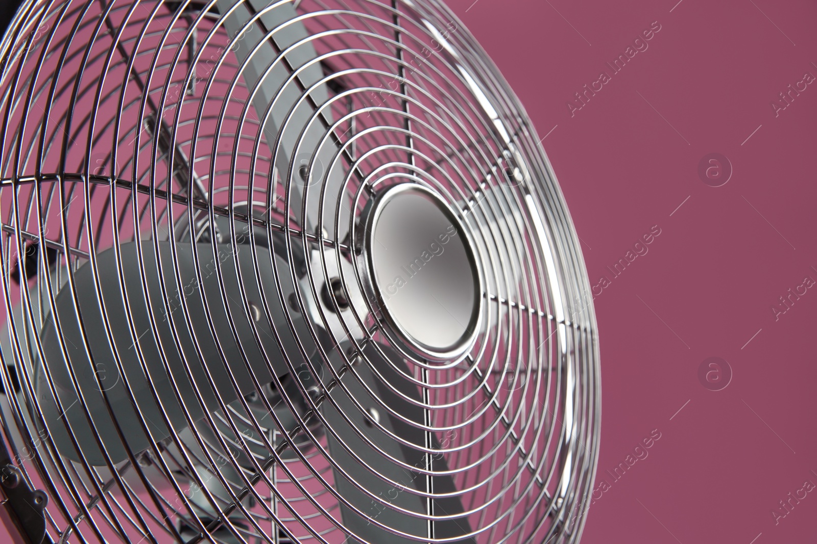 Modern electric fan on pink background, closeup Photo of Modern electric fan on pink background, closeup