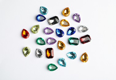 Different beautiful gemstones on white background, top view Image of Different beautiful gemstones on white background, top view