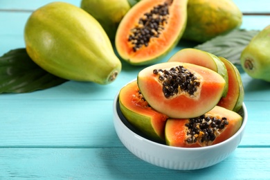 Fresh ripe papaya fruits on turquoise wooden table Photo of Fresh ripe papaya fruits on turquoise wooden table