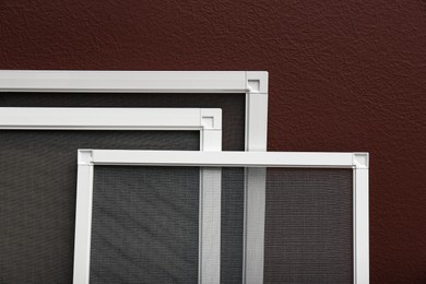 Set of window screens near brown wall, closeup Photo of Set of window screens near brown wall, closeup