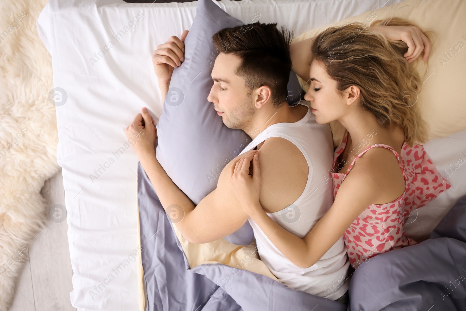 Lovely young couple sleeping in bed at home Photo of Lovely young couple sleeping in bed at home