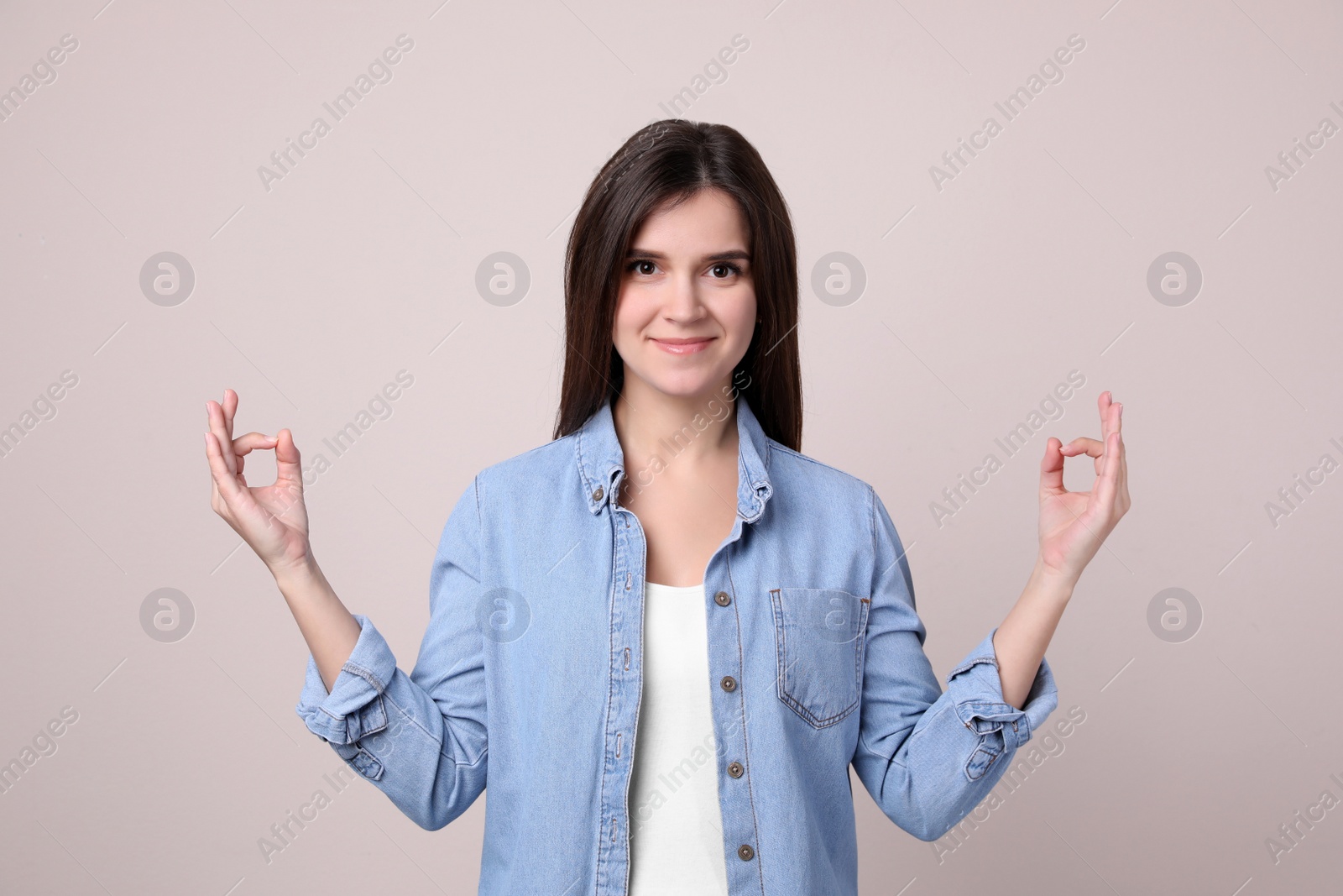 Young woman meditating on light background. Stress relief exercise Photo of Young woman meditating on light background. Stress relief exercise