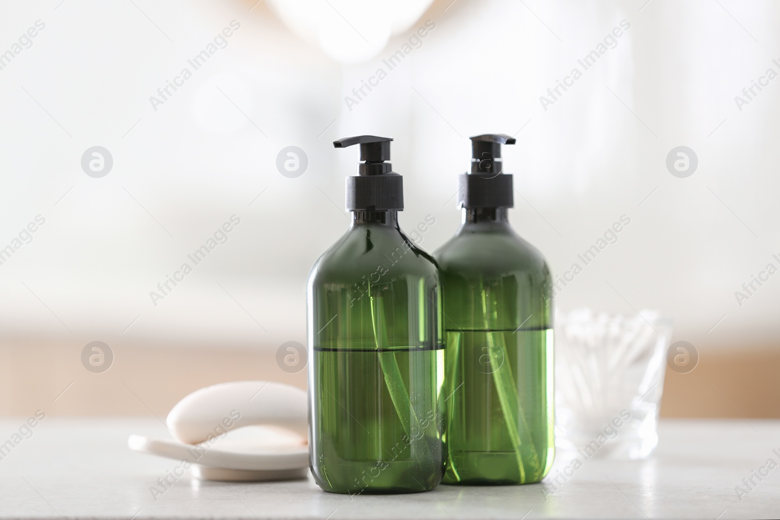 Green soap dispensers on white countertop in bathroom Photo of Green soap dispensers on white countertop in bathroom