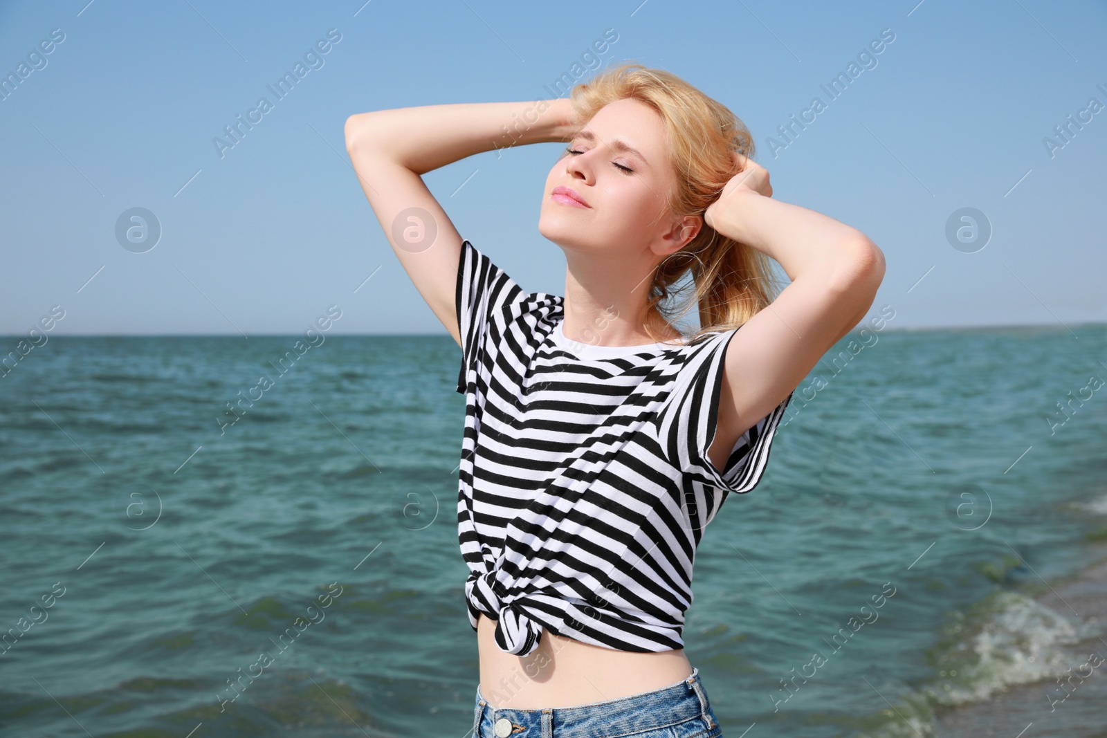 Beautiful young woman near sea on sunny day in summer Photo of Beautiful young woman near sea on sunny day in summer