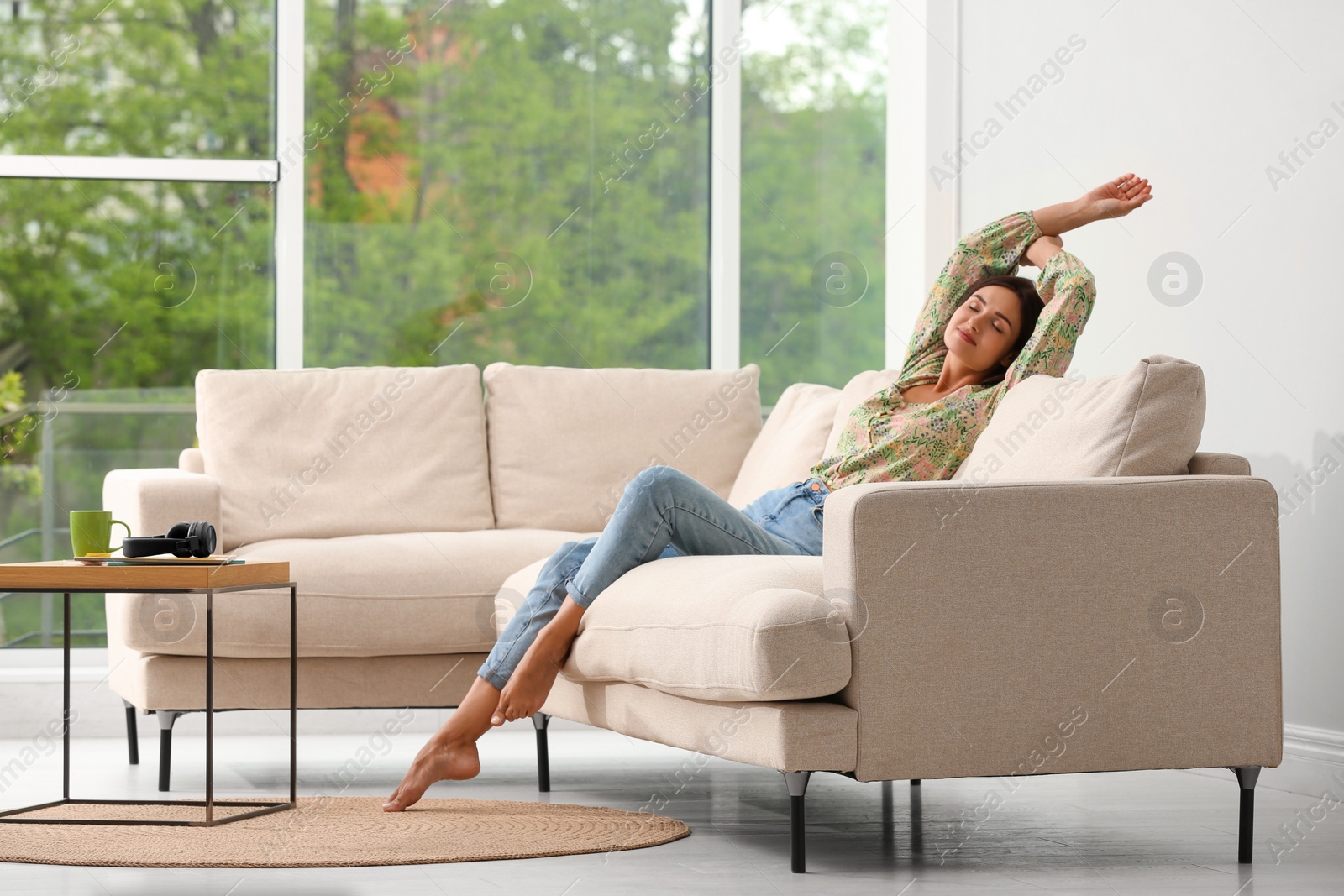 Young woman relaxing on sofa at home Photo of Young woman relaxing on sofa at home