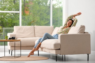 Young woman relaxing on sofa at home Photo of Young woman relaxing on sofa at home