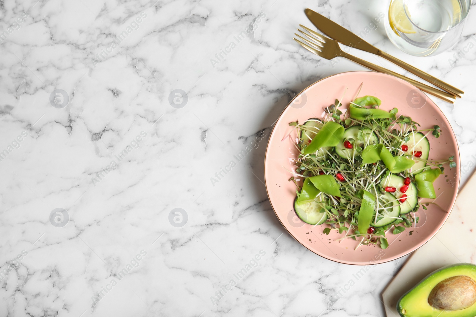 Salad with fresh organic microgreen in bowl on white marble table, flat lay. Space for text Photo of Salad with fresh organic microgreen in bowl on white marble table, flat lay. Space for text