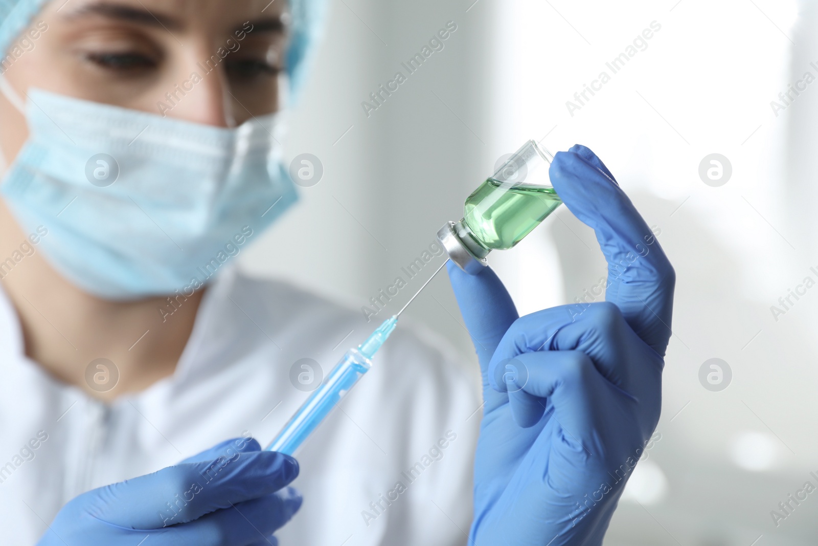 Doctor filling syringe with medication in clinic, focus on hands. Vaccination and immunization Photo of Doctor filling syringe with medication in clinic, focus on hands. Vaccination and immunization